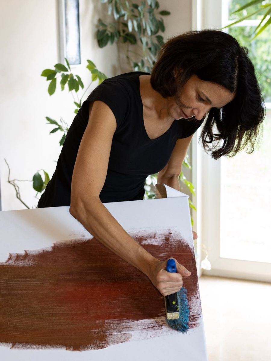 Artisanat — peintre appliquant un fond ocre sur une toile