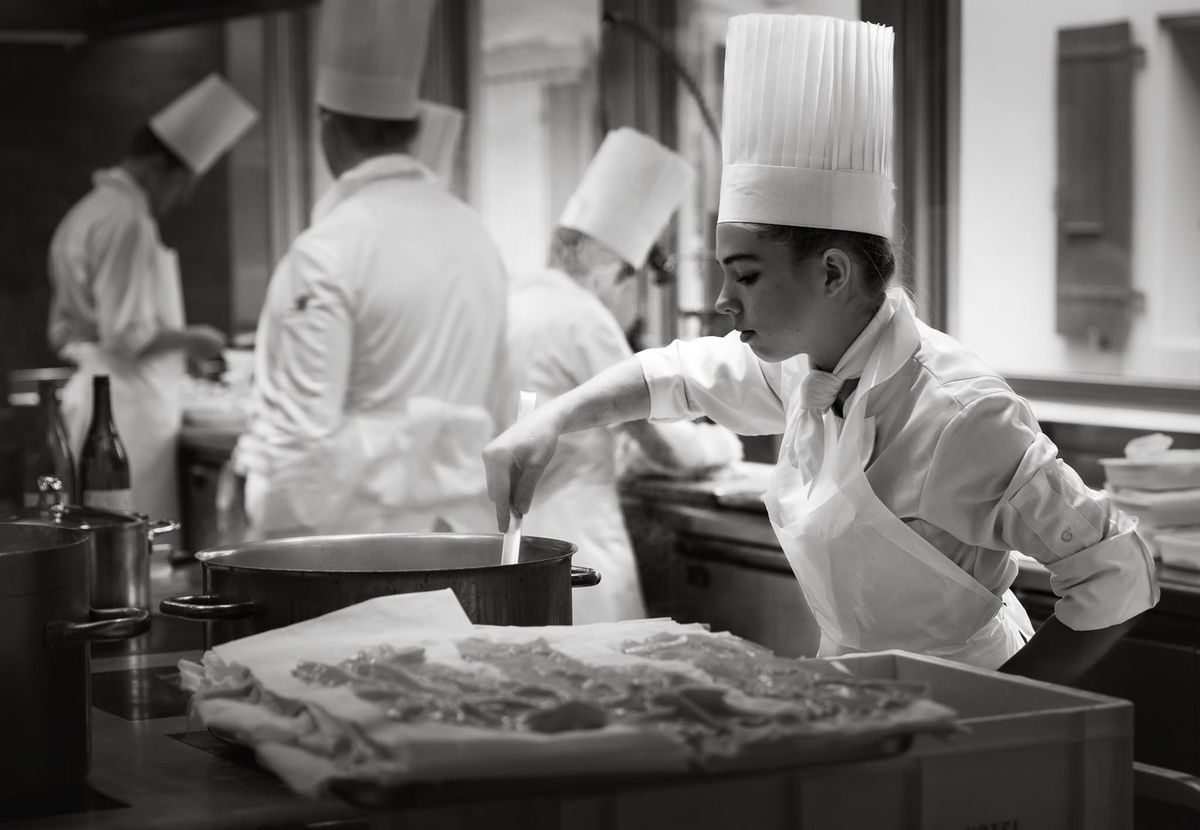 Gastronomie — jeune cheffe concentrée sur sa préparation