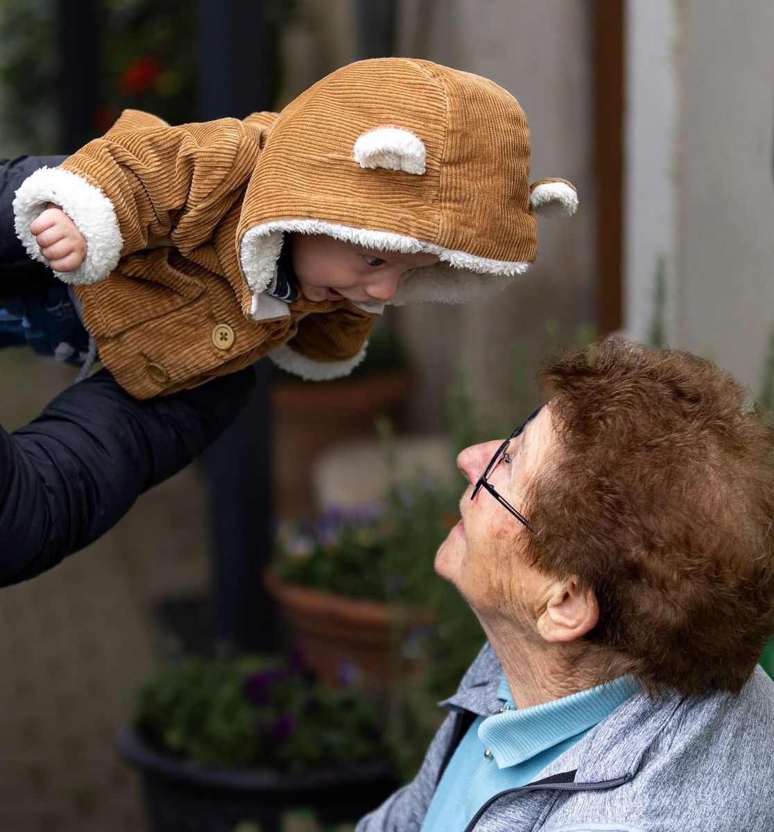 Intergénérationnel — bébé porté face à son arrière-grand-mère