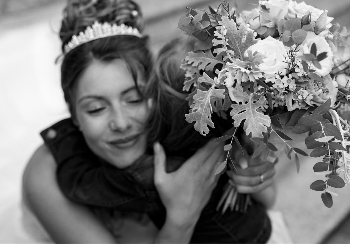 Mariage — séquence émotion, câlin et bouquet en noir et blanc