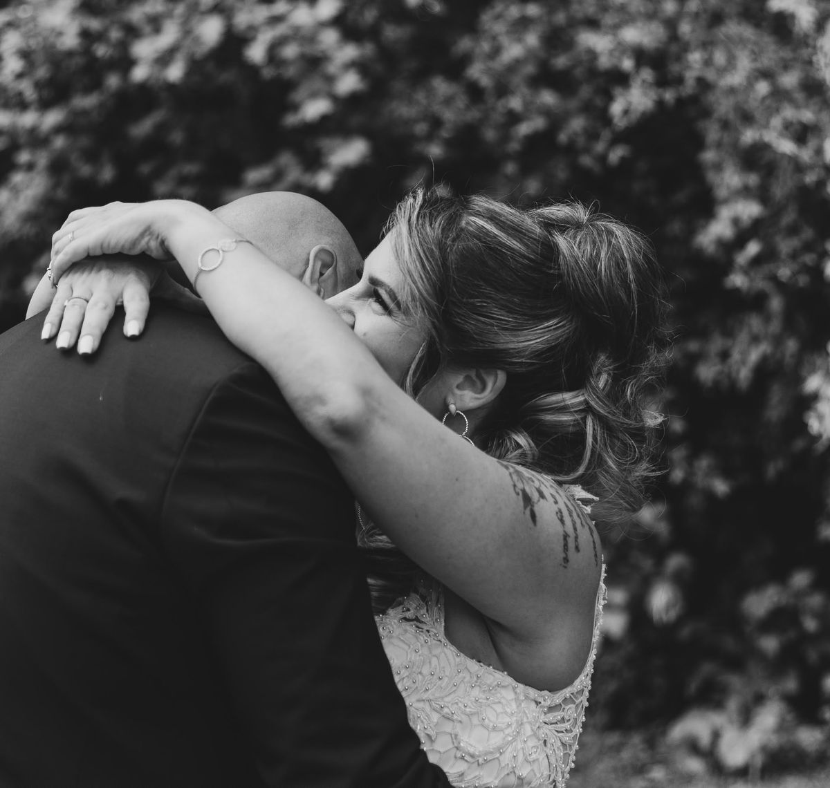 Mariage — étreinte tendre des mariés en noir et blanc