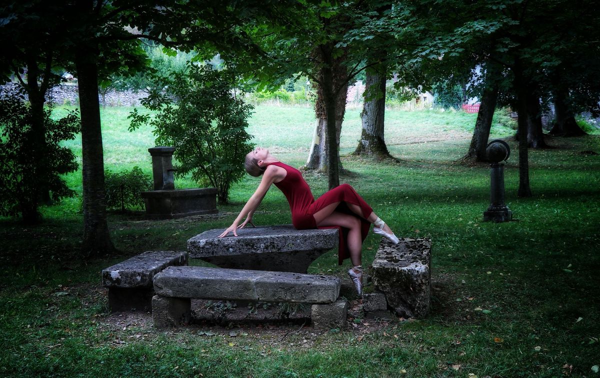 Projets personnels — danseuse en robe rouge cambrée sur une table de pierre
