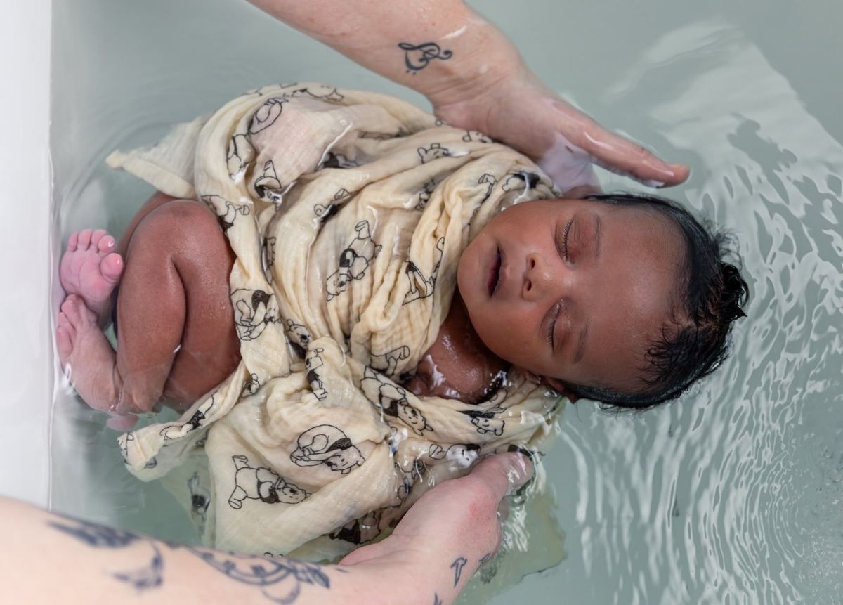 Thérapeutique Bain Bébé — bébé emmailloté dans le bain